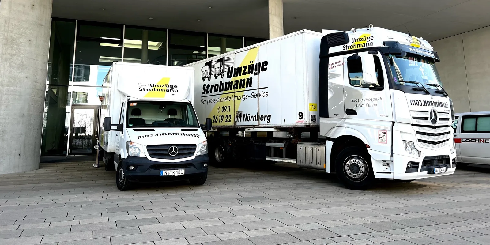 Strohmann-Fuhrpark: Sprinter, Atego und Actros-Sattelzug vor einem Firmengebäude, Kennzeichen N-TK