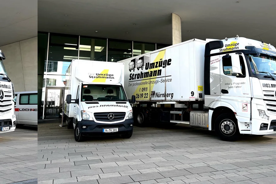 Zwei Strohmann-Fahrzeuge vor einem Gebäude: Transporter und Sattelzug mit Wechselbrücke