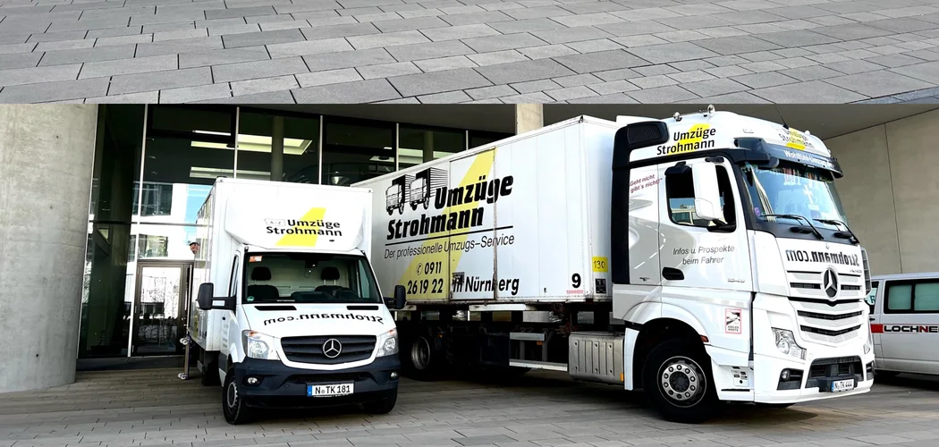 Strohmann-Transporter N-TK 181 mit Kofferaufbau, daneben eine Wechselbrücke und eine Sattelzugmaschine