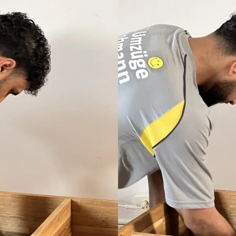 Mitarbeiter im grauen Strohmann-Shirt beugt sich über ein Holzmöbel
